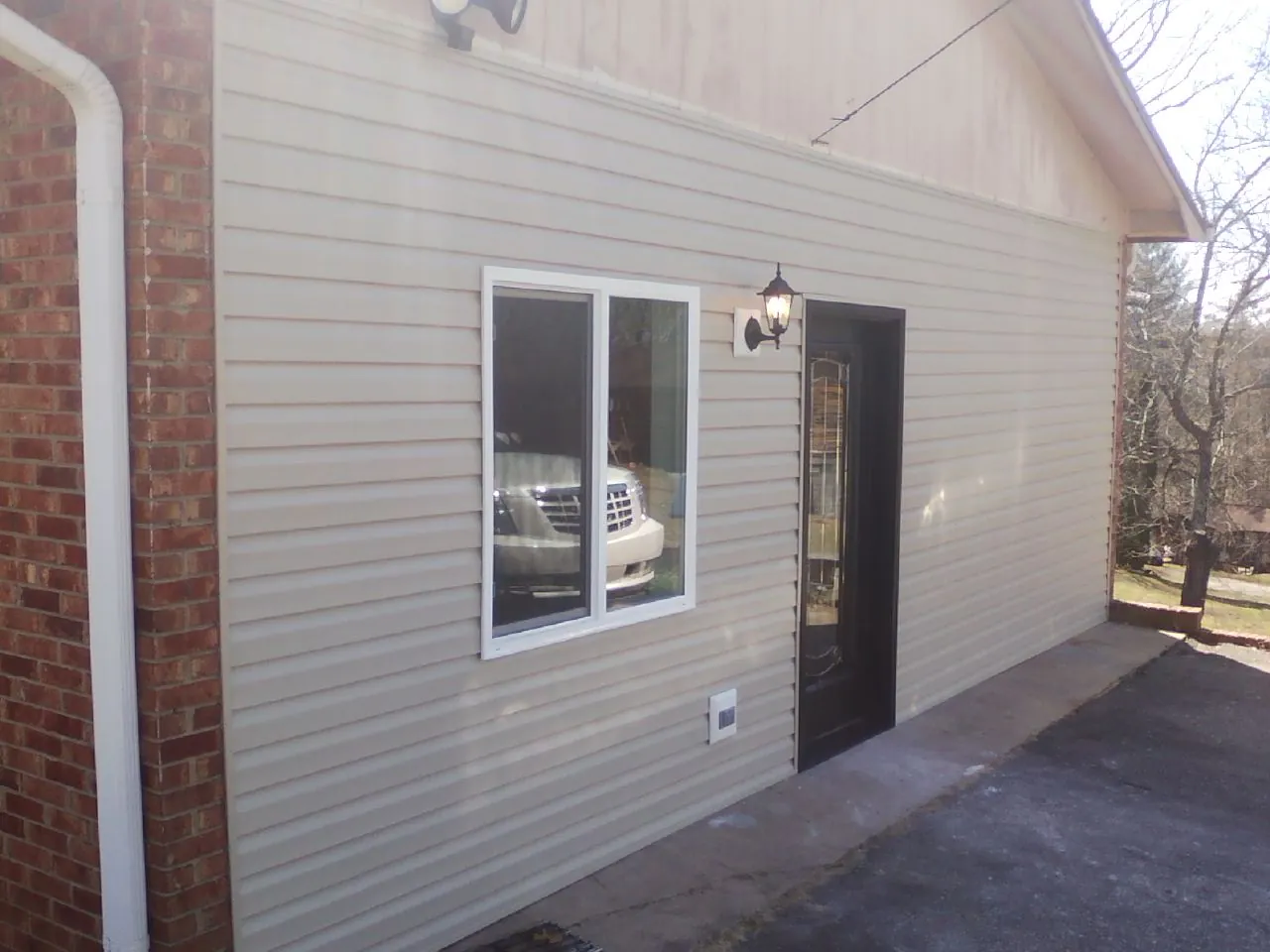 New vinyl siding and entry door on a room addition in Harrisville