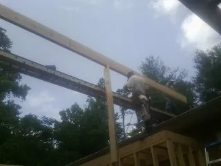 Carpenter setting a ridge beam over a new addition frame — Ice Dam Removal by Roofing Brothers in Harrisville